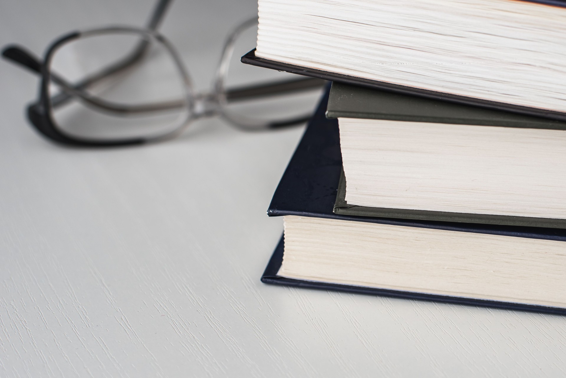 Pilha de livros e óculos de leitura como um conceito de educação e leitura de livros sobre um fundo branco.